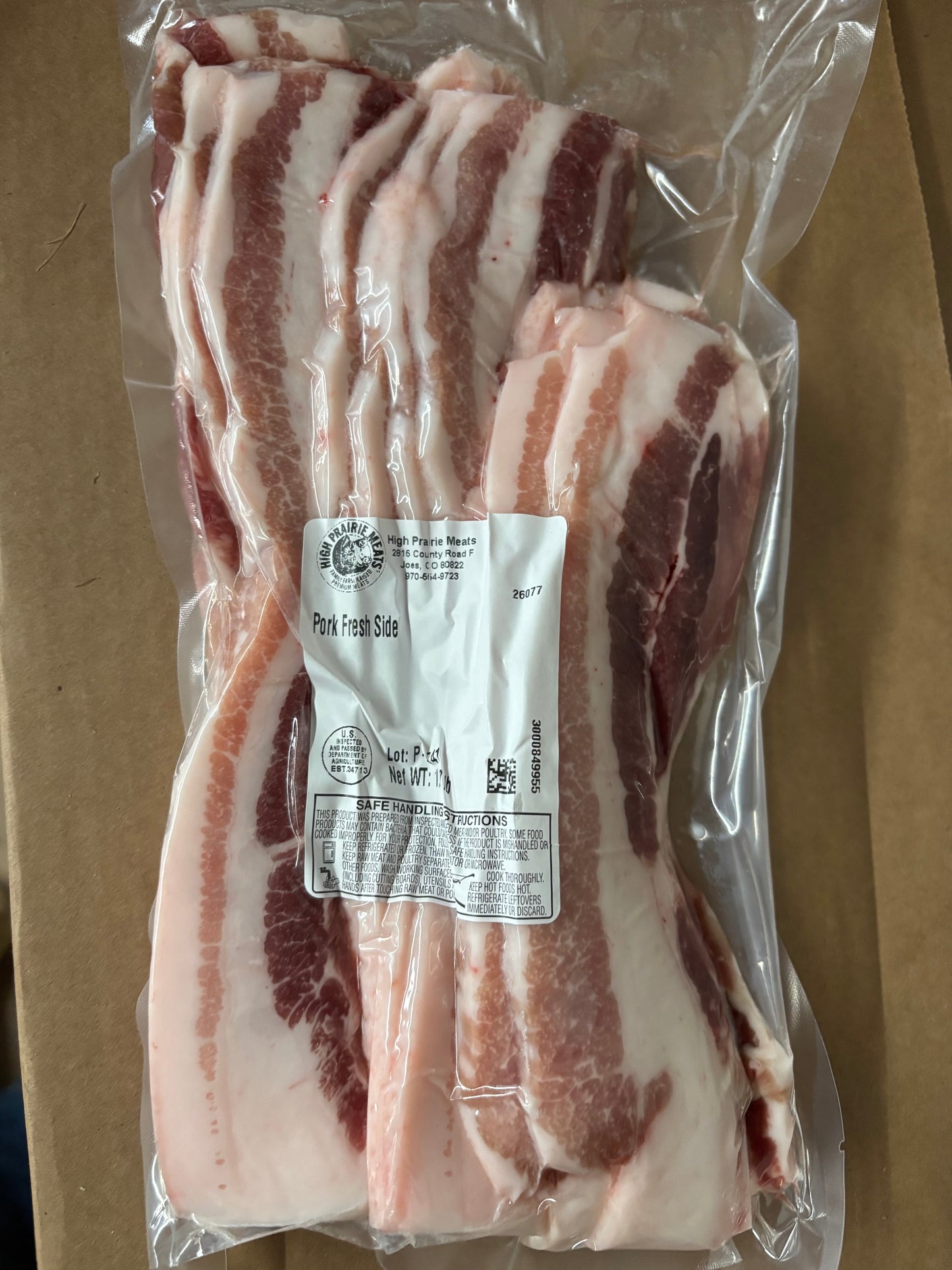 Pork fresh side, Packaged slices of meat with a label on a cardboard background