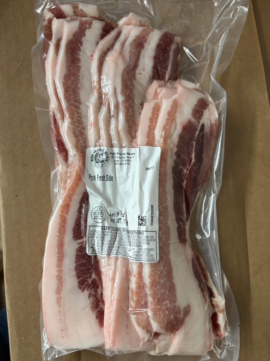 Pork fresh side, Packaged slices of meat with a label on a cardboard background